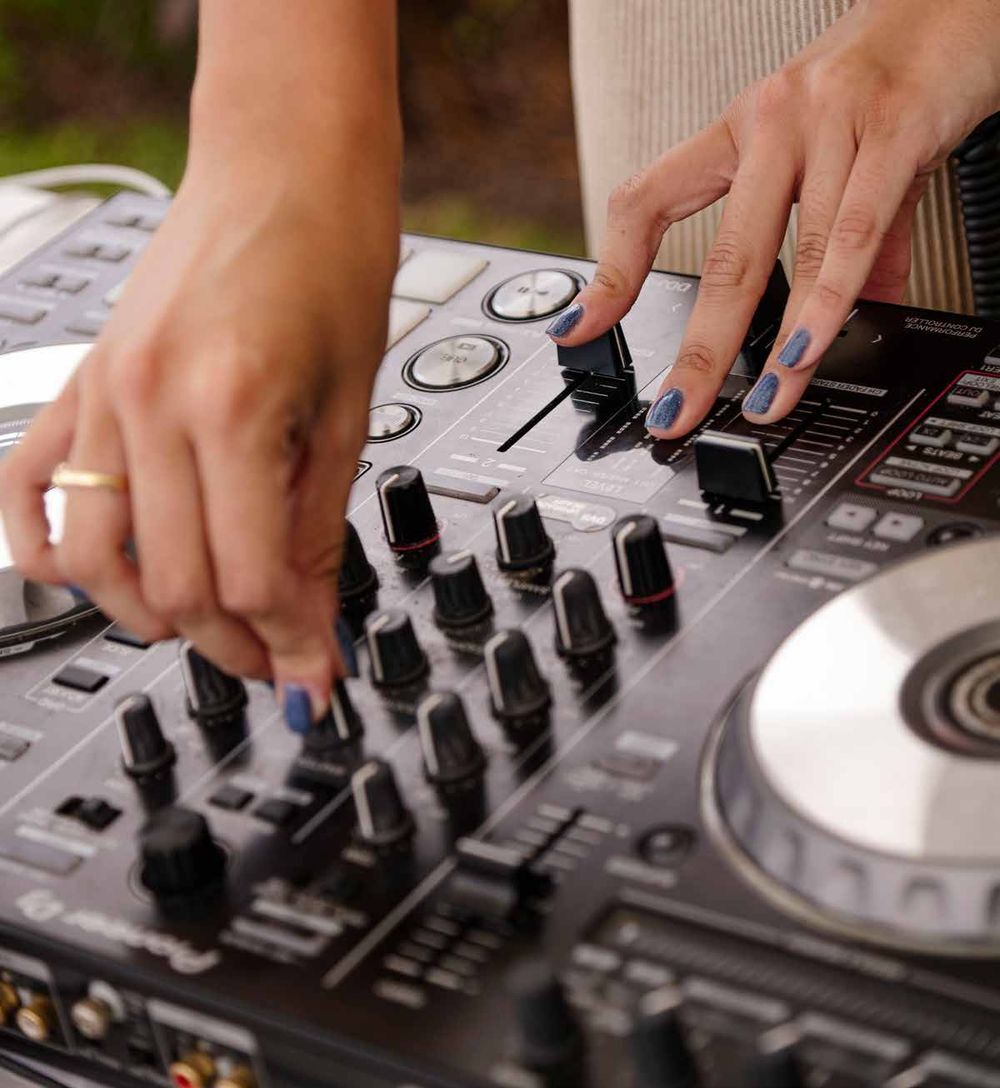 DJ en evento al aire libre, manos en consola